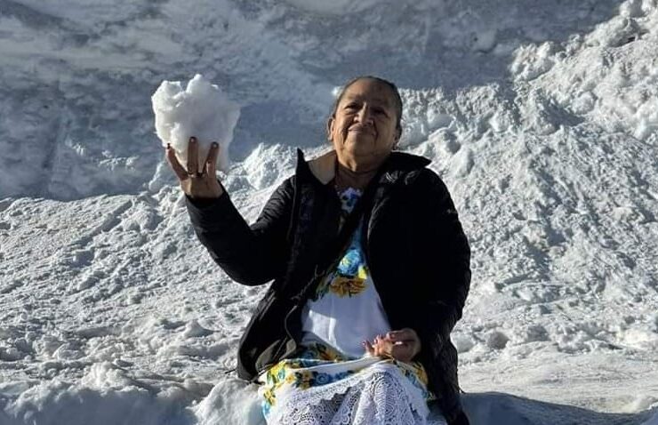 Mamá morena aparece radiante y sonriente, ataviada con el tradicional huipil yucateco, mientras disfruta del manto blanco de la nieve
