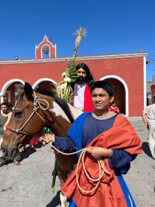 Feligreses acompañan la emotiva procesión durante el viacrucis viviente en Baca, en el marco de la celebración que marcó la llegada del Domingo de Ramos en la comunidad.