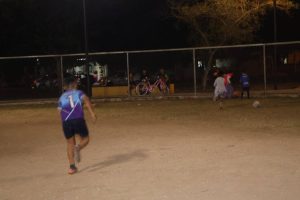 La cancha presenta postes de alumbrado y superficies irregulares, un peligro constante para los menores que practican deporte en este espacio comunitario.