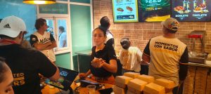 Aficionados disfrutan la Alianza con sabor en el Kukulcán, combinando béisbol y hamburguesas premium durante el juego de los Leones de Yucatán.